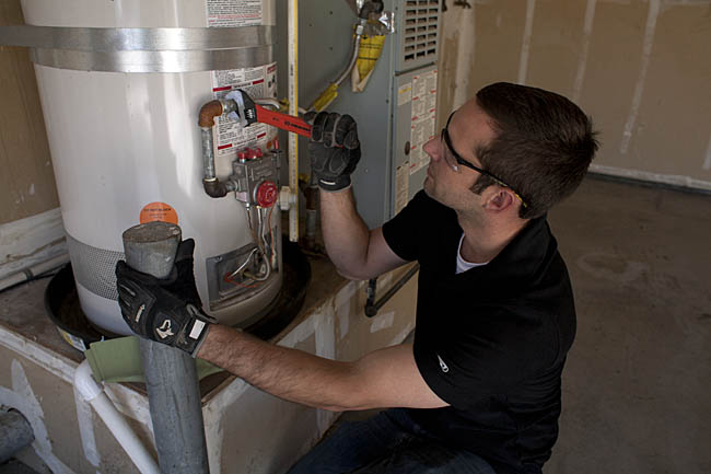 repairing a water heater in a Millbrae garage